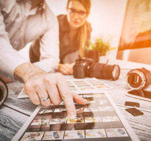 Dos fotógrafos eligiendo miniaturas de fotografías